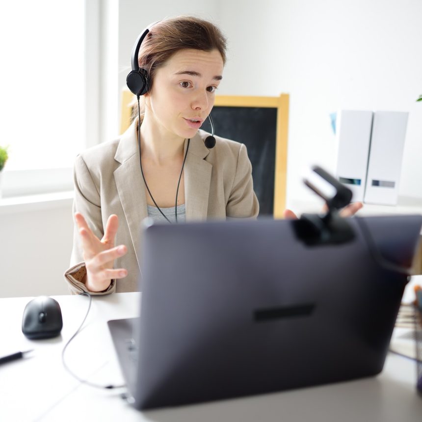 young-woman-is-learning-language-with-laptop-computer-camcorder-and-headphone-online-at-home-1-1